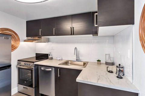 a kitchen with stainless steel appliances and marble counter tops